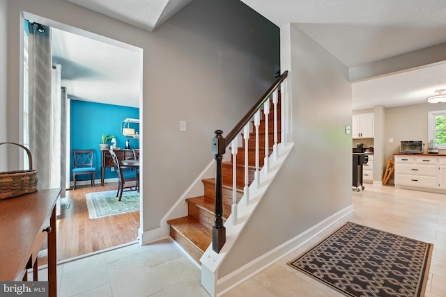 stairway featuring baseboards and tile patterned floors