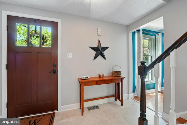 entryway featuring stairway, baseboards, and visible vents