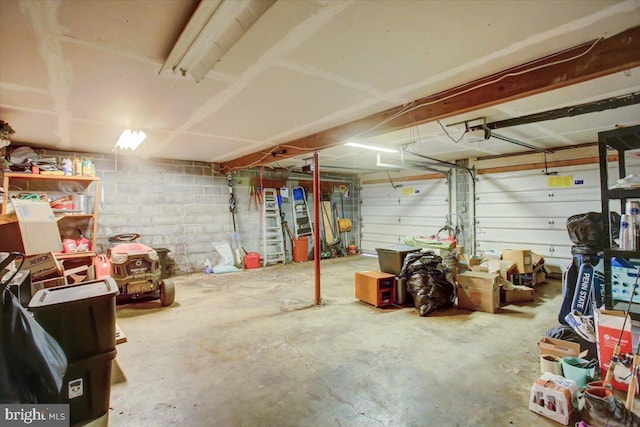 garage with a garage door opener and concrete block wall