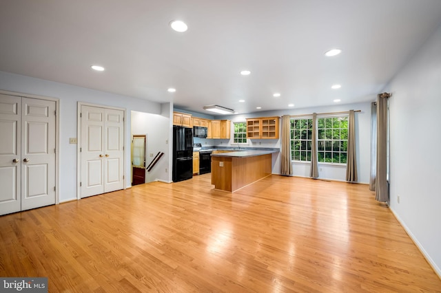 5303 Dew Garth, Baltimore, MD 21206 - kitchen with black appliances, a peninsula, light wood-type flooring, and glass insert cabinets