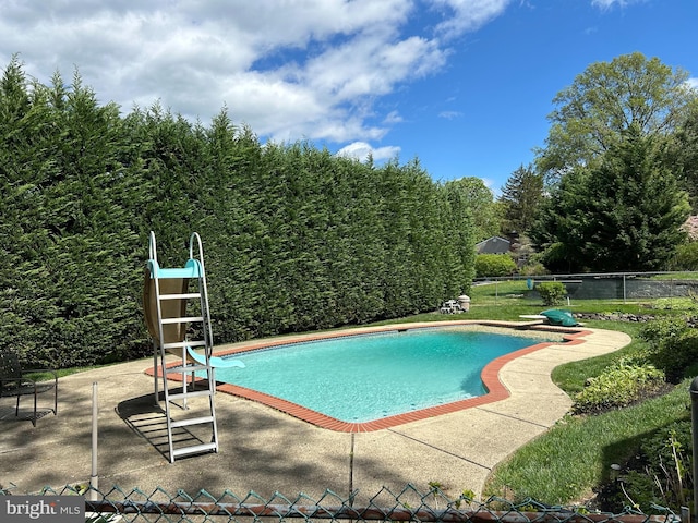view of pool with a patio, a fenced in pool, a water slide, a diving board, and fence