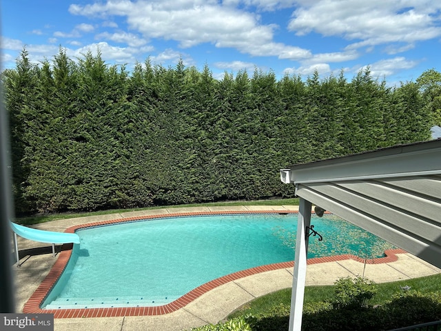 view of swimming pool with a water slide and a fenced in pool