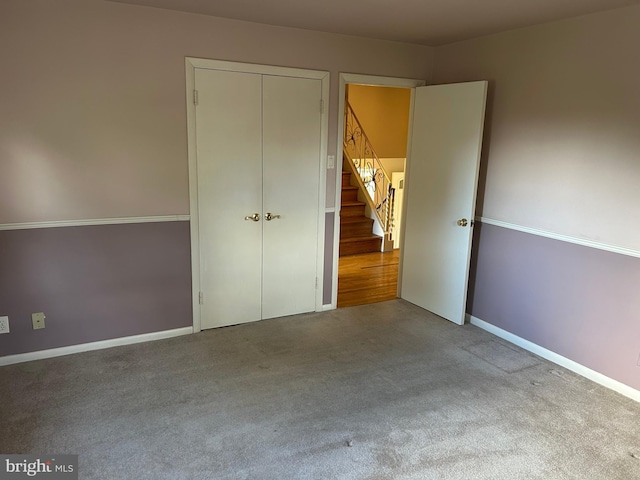 unfurnished bedroom with a closet, carpet flooring, and baseboards