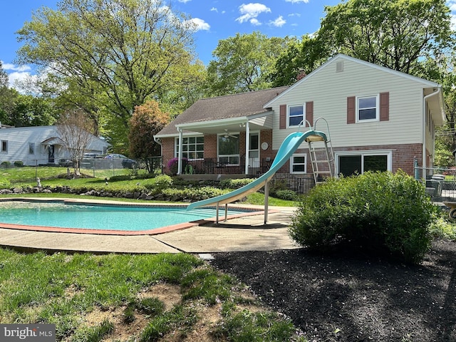 exterior space with a chimney, brick siding, fence, a ceiling fan, and an outdoor pool