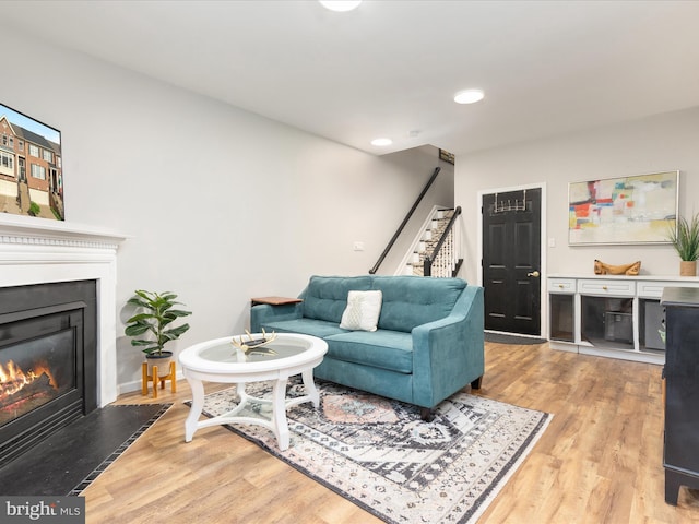 20636 Muddy Harbour Sq, Sterling, VA 20165 - living area with a glass covered fireplace, light wood-style floors, stairway, and recessed lighting