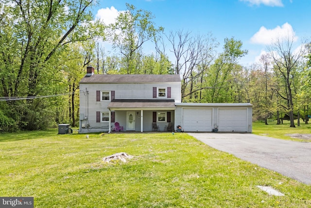 traditional-style home with an attached garage, a front lawn, driveway, and a chimney