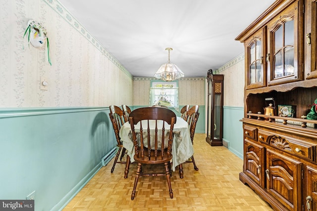 dining area with wallpapered walls, a notable chandelier, baseboards, and a wainscoted wall