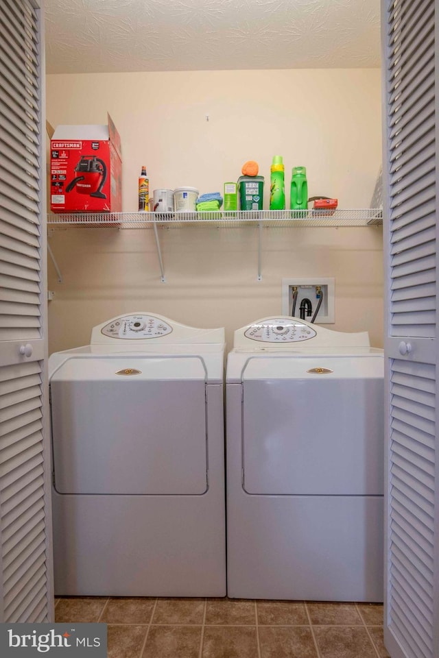 laundry room with tile patterned floors, washing machine and clothes dryer, and laundry area