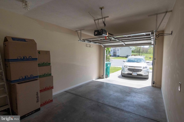 garage with a garage door opener and baseboards