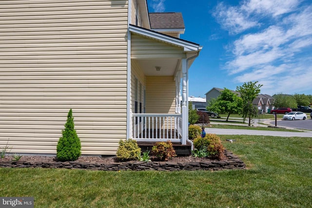 view of property exterior with a lawn, roof with shingles, and covered porch