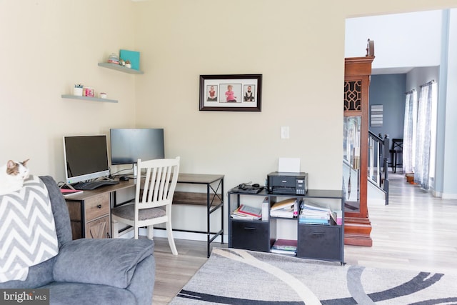 home office with baseboards and wood finished floors