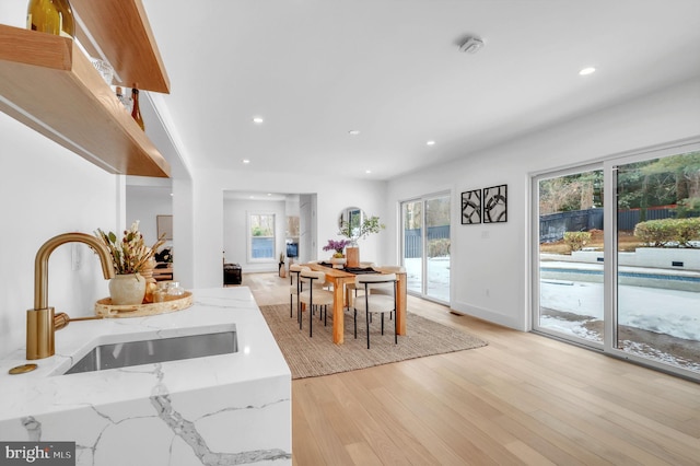 dining space with recessed lighting, a wealth of natural light, and light wood-type flooring
