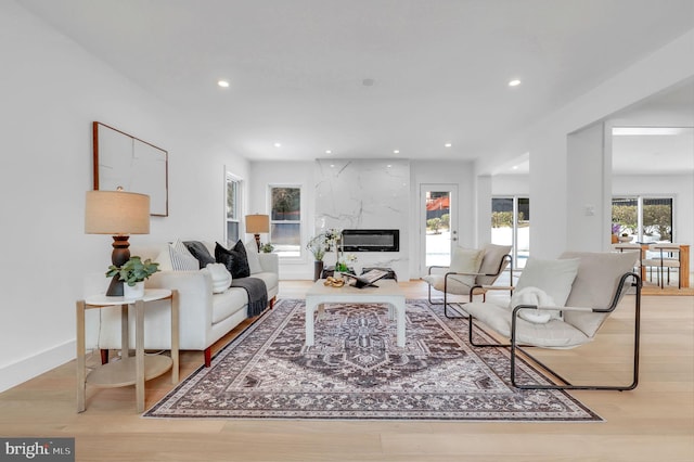 living room with recessed lighting, wood finished floors, and a premium fireplace