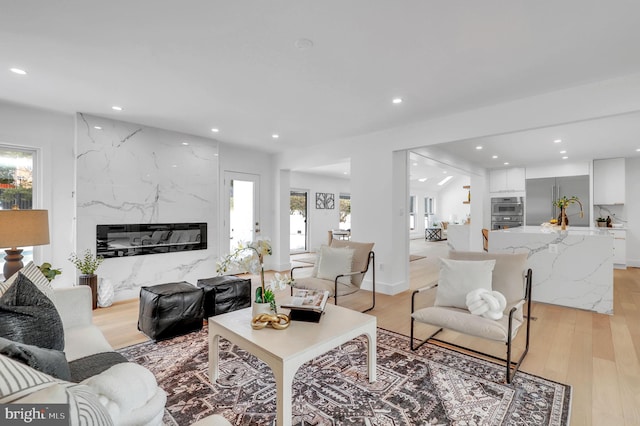 living area featuring recessed lighting, light wood-style flooring, and a wealth of natural light