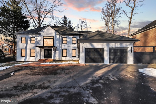 view of front facade with fence, an attached garage, and driveway