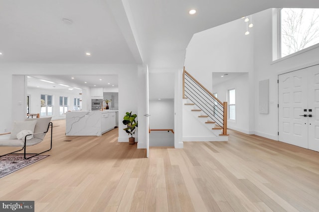 entryway with stairs, recessed lighting, baseboards, and light wood-type flooring