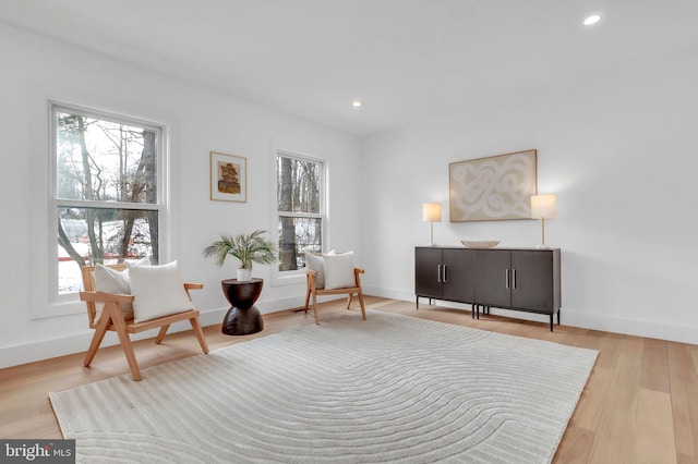 living area with baseboards, recessed lighting, and wood finished floors