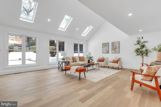 living room with light wood-style floors, high vaulted ceiling, recessed lighting, baseboards, and a skylight