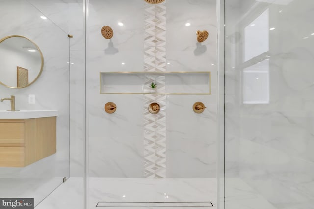 full bathroom featuring a marble finish shower and vanity