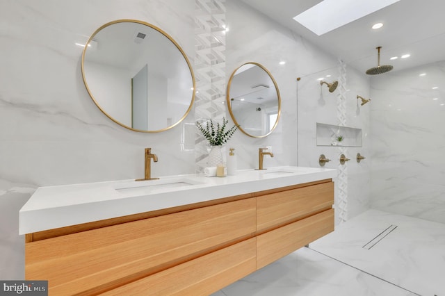 bathroom with double vanity, a sink, a marble finish shower, and a skylight