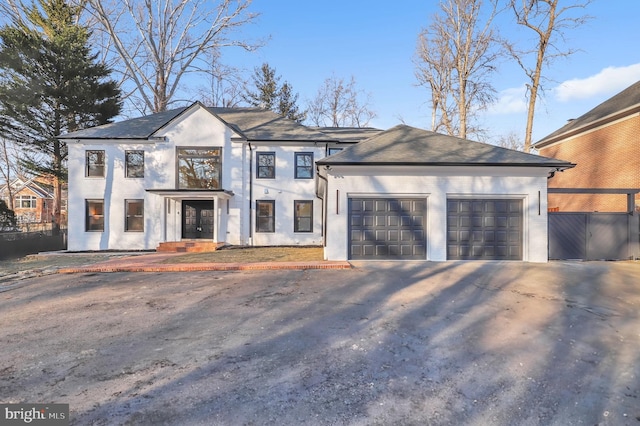 view of front of property featuring fence, an attached garage, driveway, and stucco siding