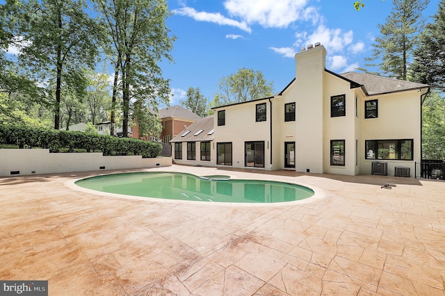 view of swimming pool featuring a fenced in pool, cooling unit, and a patio area