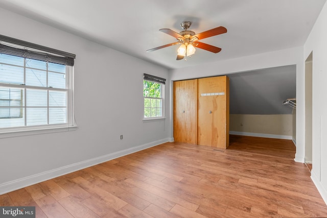 unfurnished bedroom featuring a ceiling fan, baseboards, light wood finished floors, and a closet