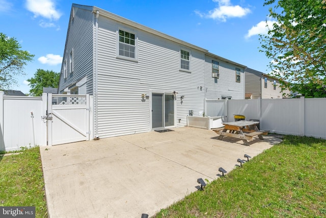 rear view of house featuring a patio, a gate, and fence