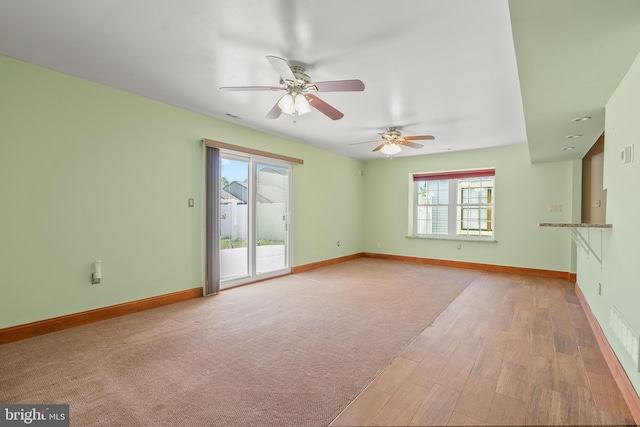 unfurnished living room featuring baseboards, a ceiling fan, and wood finished floors