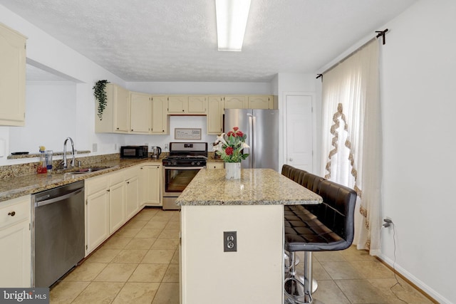 kitchen featuring a sink, stainless steel appliances, a breakfast bar, light tile patterned floors, and a kitchen island