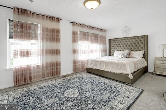 bedroom with carpet floors, baseboards, and visible vents
