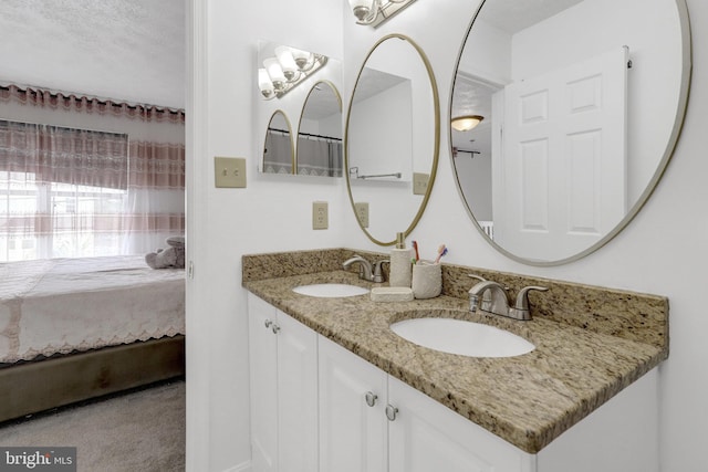 ensuite bathroom featuring a sink, double vanity, and ensuite bath
