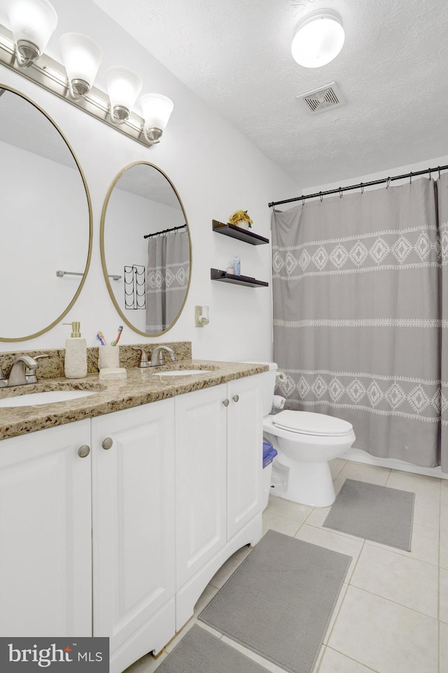 full bath featuring a sink, tile patterned flooring, a textured ceiling, and visible vents