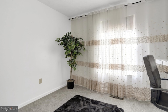 carpeted office space featuring baseboards