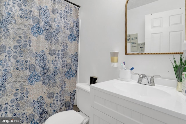 bathroom with toilet, vanity, and a shower with shower curtain