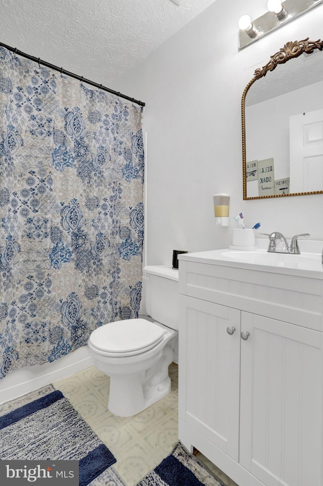 bathroom featuring vanity, a textured ceiling, and toilet