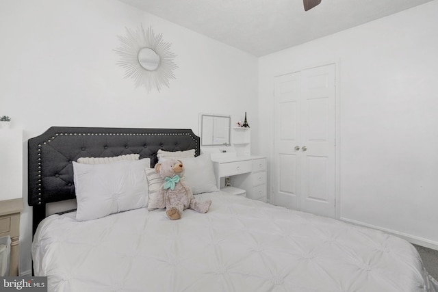 carpeted bedroom with ceiling fan and baseboards