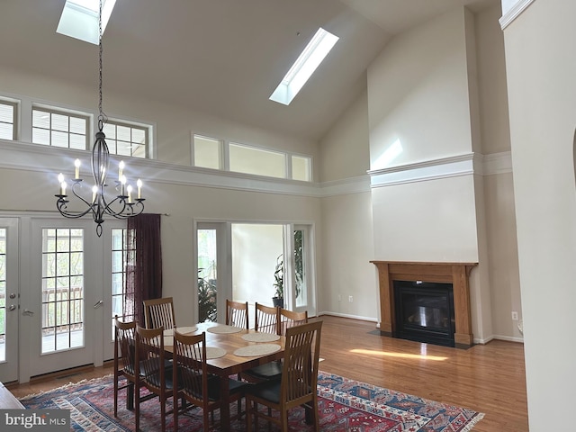 2435 Mill Race Rd, Frederick, MD 21701 - dining room with a skylight, wood finished floors, high vaulted ceiling, an inviting chandelier, and a fireplace with flush hearth