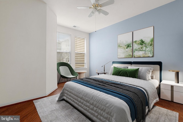 bedroom with wood finished floors, visible vents, ceiling fan, and baseboards