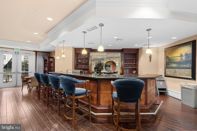 bar featuring indoor wet bar, visible vents, dark wood-style flooring, and hanging light fixtures