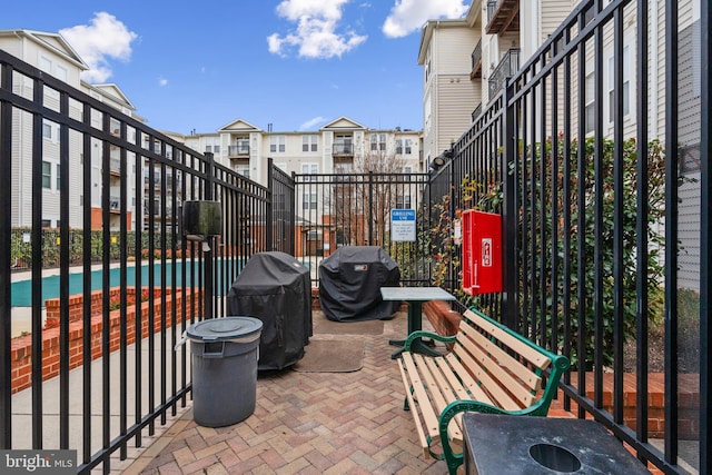 view of patio / terrace with area for grilling, a community pool, and fence