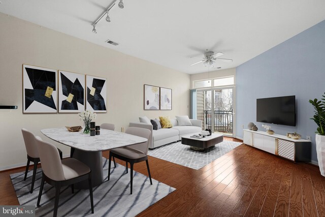 living area with a ceiling fan, visible vents, wood finished floors, and baseboards