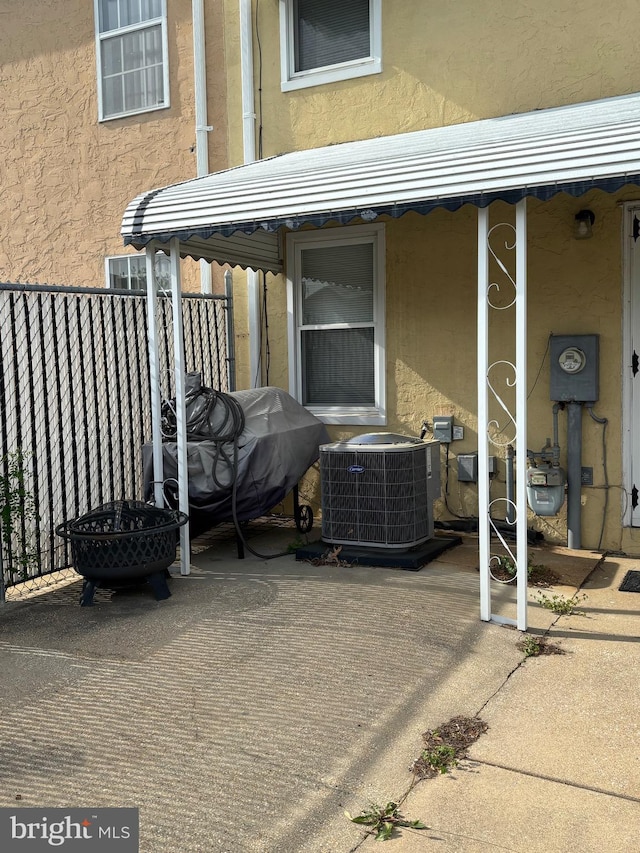 view of patio / terrace with cooling unit and fence