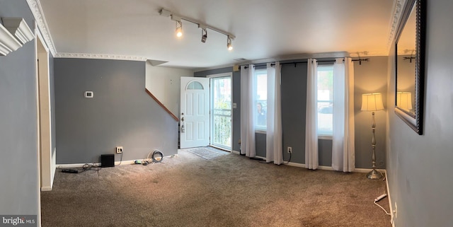 unfurnished room with carpet flooring, rail lighting, and baseboards