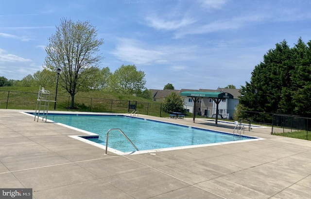 community pool with a patio and fence