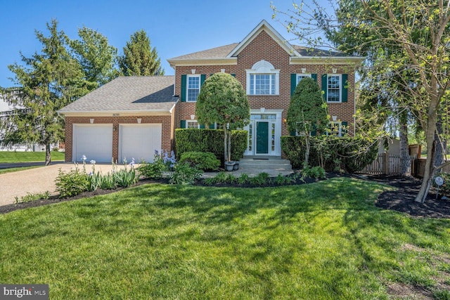 colonial inspired home with a garage, concrete driveway, a front yard, and brick siding