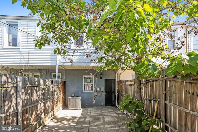3429 E Lombard St, Baltimore, MD 21224 - rear view of house with stucco siding, cooling unit, and fence
