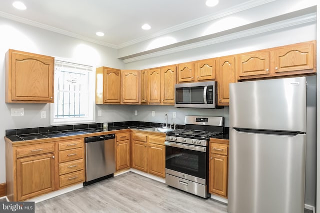 3429 E Lombard St, Baltimore, MD 21224 - kitchen with appliances with stainless steel finishes, light wood finished floors, a sink, ornamental molding, and recessed lighting