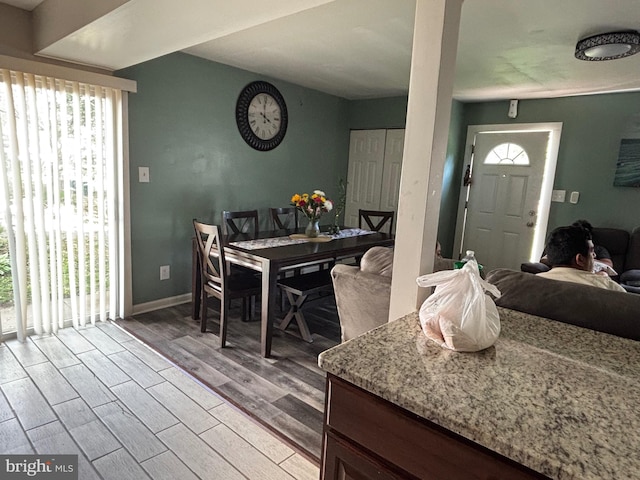 dining space featuring a wealth of natural light, wood finished floors, and baseboards
