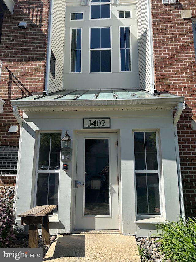 view of exterior entry with brick siding